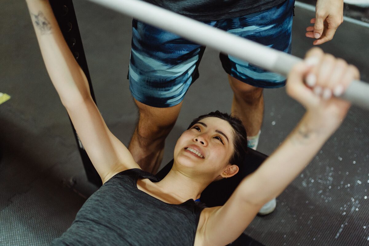 A woman at a bench press, shot from above, looking up at the bar &mdash; the frame the colour filters are previewed on.